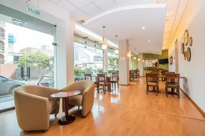 a dining room with tables and chairs in a building at Del Prado Hotel in Lima