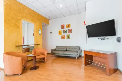 a living room with a couch and a flat screen tv at Del Prado Hotel in Lima