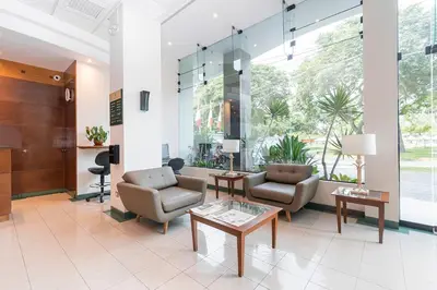 a lobby with couches and chairs and a table at Del Prado Hotel in Lima