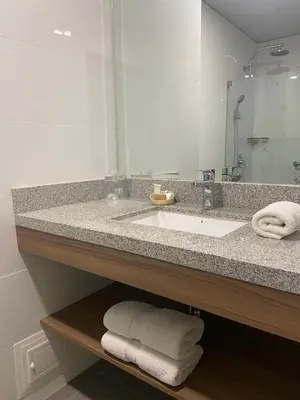 a bathroom with a sink and a mirror and towels at Del Prado Hotel in Lima