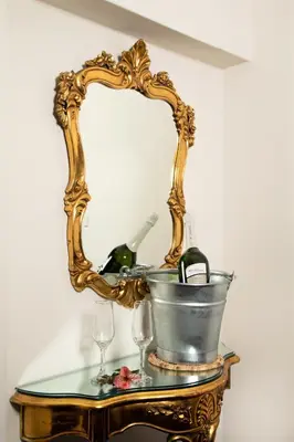 a mirror on a table with a bucket and wine glasses at Atoq San Blas Hotel in Cusco