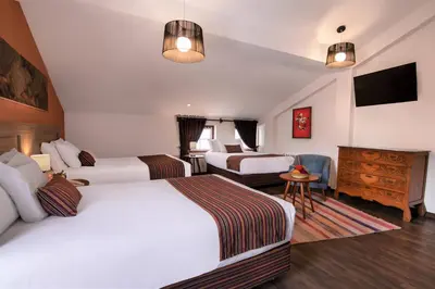 a hotel room with two beds and a television at Atoq San Blas Hotel in Cusco
