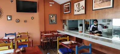 a man standing behind a counter in a restaurant at Atoq San Blas Hotel in Cusco