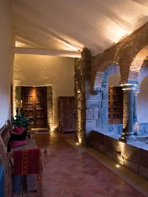 a room with a stone wall and a table in a building at Inkaterra La Casona Relais & Chateaux in Cusco