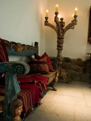 a room with a bench with two candles and a mirror at Inkaterra La Casona Relais & Chateaux in Cusco