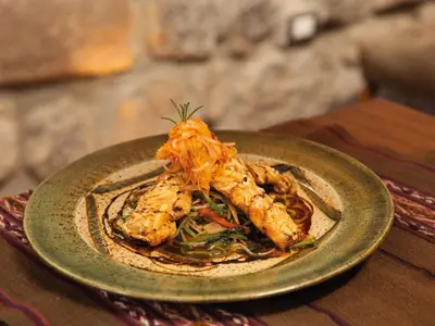 a plate of food with shrimp on a table at Inkaterra La Casona Relais & Chateaux in Cusco