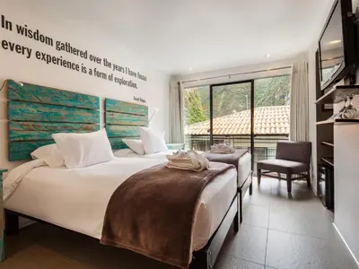 a bedroom with two beds and a large window at El MaPi by Inkaterra in Machu Picchu