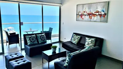 a living room with couches and a view of the ocean at Duplex 1 Fila Vista Bahía Paracas - Sotavento 501 T3 in Paracas
