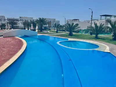 a swimming pool with blue water in a resort at Duplex 1 Fila Vista Bahía Paracas - Sotavento 501 T3 in Paracas