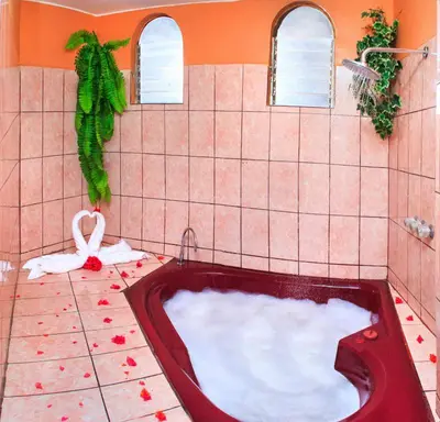 a bath tub in a tiled bathroom with a red bath tub at Hotel Princess in Ica