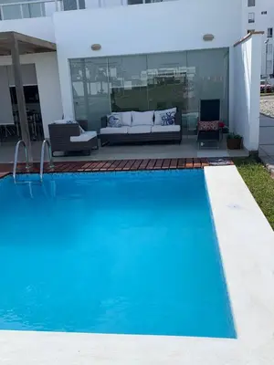 a swimming pool in front of a house at Condominios Nauticos Nuevo Paracas in Paracas