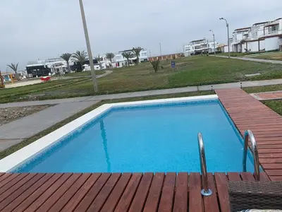 a small blue swimming pool with a wooden deck at Condominios Nauticos Nuevo Paracas in Paracas