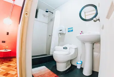 a bathroom with a toilet and a sink at Supertramp Hostel Machupicchu in Machu Picchu