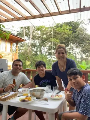 a group of people sitting around a table eating food at Refugio de Orquídeas in Oxapampa