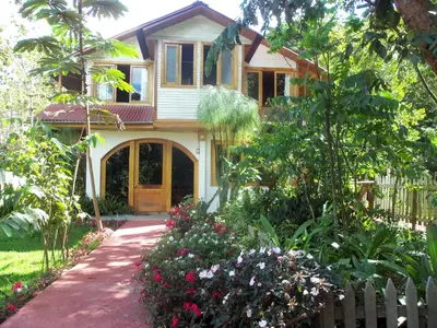 a small house with a fence and a garden at Refugio de Orquídeas in Oxapampa