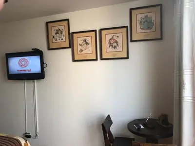 a room with a tv and pictures on the wall at A Perfect Vacation Getaway Apartment in Lima