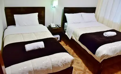 two beds in a hotel room with towels on them at Machupicchu Guest House in Machu Picchu