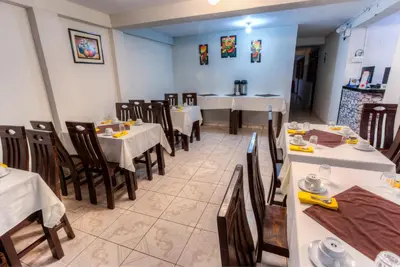 a dining room with tables and chairs in a restaurant at Machupicchu Guest House in Machu Picchu