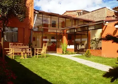 a house with a yard with chairs and a patio at Hostal Samichay in Cusco