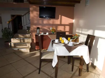 a table and chairs in a room with a television at Hostal Samichay in Cusco