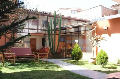 a house with a cactus in the yard at Hostal Samichay in Cusco