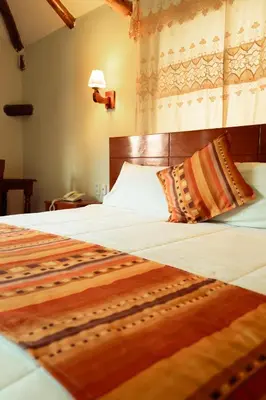 a bedroom with a large bed with a wooden headboard at Siete Ventanas in Cusco