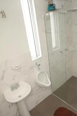 a bathroom with a sink and a urinal and a shower at Barranco Wasi in Lima