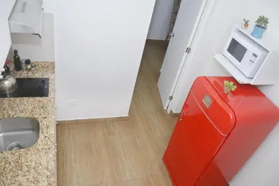 a red refrigerator in a kitchen with a microwave at Barranco Wasi in Lima