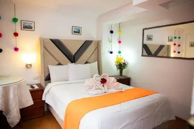 a hotel room with a bed with a flower on it at Hostal Tu Hogar in Cusco