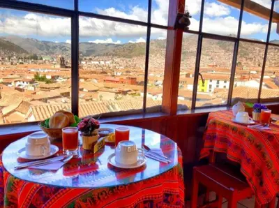 a table with a view of a city from a window at Hostal Tu Hogar in Cusco