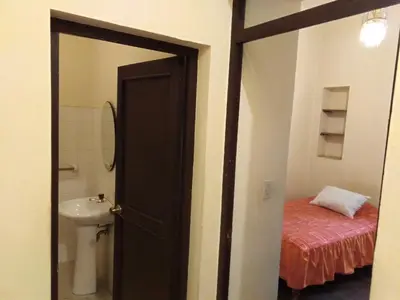 an open door to a bathroom with a sink and a toilet at El Tuco Hotel in Cusco