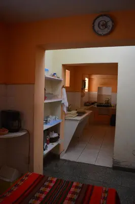 a kitchen with an open door to a kitchen with a counter at El Tuco Hotel in Cusco