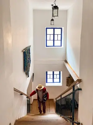 a man walking down a staircase in a house at Flying Dog Hostel Cusco in Cusco
