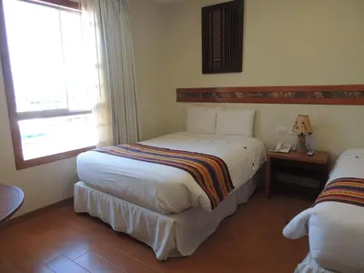 a hotel room with two beds and a window at Taypikala Hotel Cusco in Cusco