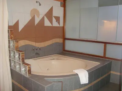 a bath tub in a bathroom with a tile wall at Taypikala Hotel Cusco in Cusco