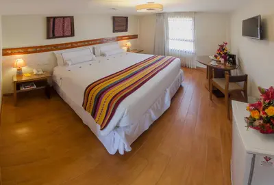 a bedroom with a large bed in a hotel room at Taypikala Hotel Cusco in Cusco