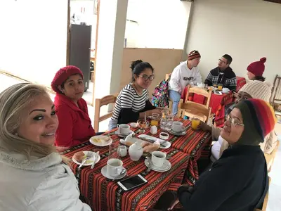 a group of people sitting at a table eating at Hostal Apu Qhawarina in Ollantaytambo