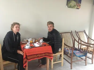 a man and a woman sitting at a table at Hostal Apu Qhawarina in Ollantaytambo