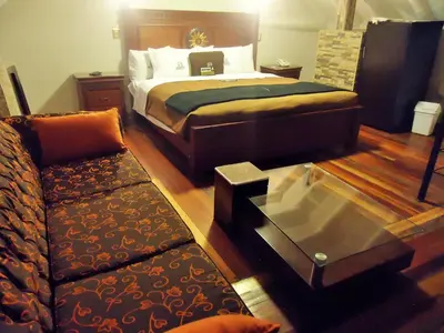 a bedroom with a bed and a couch and a table at Hotel San Francisco Plaza in Cusco