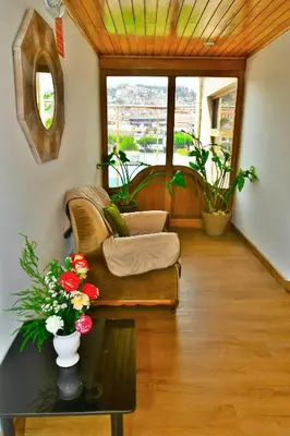 a living room with a couch and a table with flowers at Centenario Inn in Cusco