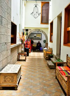 a hallway with benches and tables in a building at Centenario Inn in Cusco