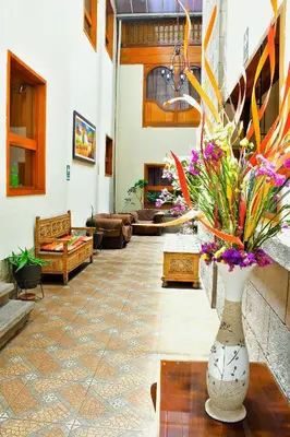 a lobby with a vase with flowers in it at Centenario Inn in Cusco