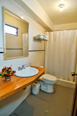 a bathroom with a sink and a toilet and a mirror at Centenario Inn in Cusco