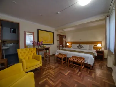 a hotel room with a bed and a yellow chair at Sol Ollantay Boutique Hotel in Ollantaytambo