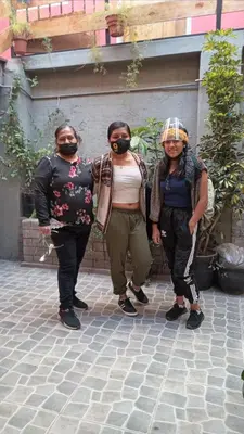 three people wearing masks standing next to a building at Casa Salkantay Cusco in Cusco