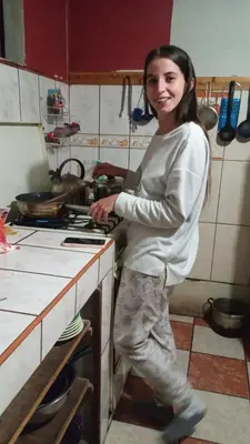a woman standing next to a stove in a kitchen at Casa Salkantay Cusco in Cusco