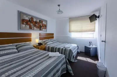 a hotel room with two beds and a window at Jose Luis Hostal Boutique in Lima