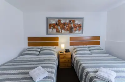two twin beds in a bedroom with a picture on the wall at Jose Luis Hostal Boutique in Lima