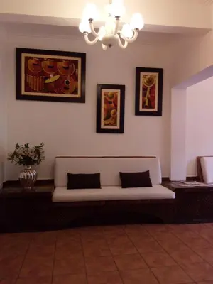 a living room with a couch and paintings on the wall at Jose Luis Hostal Boutique in Lima