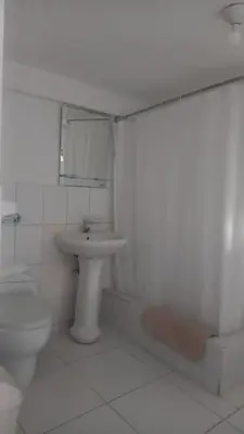 a white bathroom with a toilet and a sink at Jose Luis Hostal Boutique in Lima